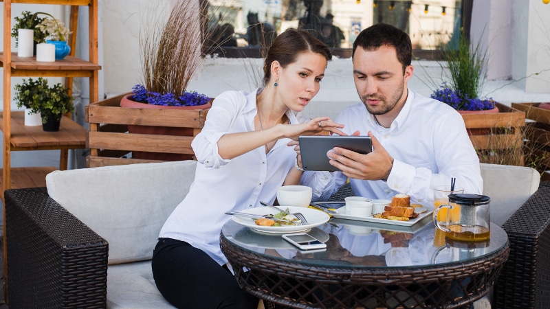 Business people looking at digital tablet in cafe during a meeting.